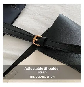 Close-up of adjustable black leather strap and gold metal buckle on a contrast tote bag