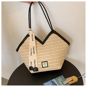 Close-up of beige woven tote bag with black trim and a decorative ribbon detail