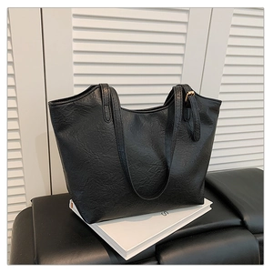 Dettaglio borsa shopper nera in finta pelle vintage con fibbie in metallo dorato