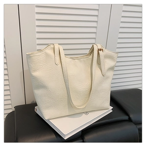 Dettaglio della borsa tote off-white con texture in pelle plissettata in stile vintage