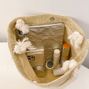 Woven straw tote bag featuring internal lining and large capacity for travel essentials