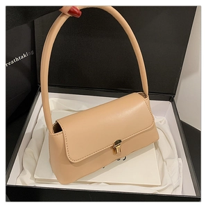 Détail d'un sac baguette beige minimaliste avec fermoir doré dans son coffret cadeau