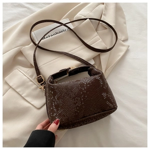 Close-up of dark brown snake-textured bucket bag with gold hardware and fine stitching