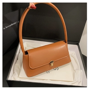 Sac sous le bras en cuir marron avec fermoir doré dans un coffret cadeau élégant