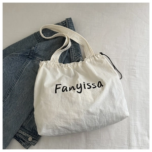 Detail of white Fanyissa canvas tote bag with drawstring and shoulder straps