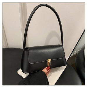 Détail du sac sous le bras en cuir noir mat avec un fermoir en métal doré chic