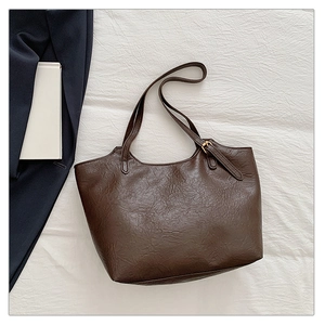 Dettaglio della borsa tote marrone scuro con pelle PU plissettata e fibbia dorata