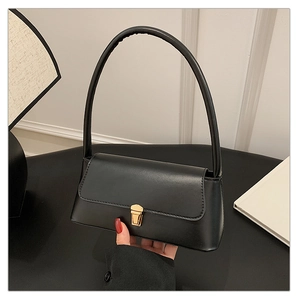 Détail d'un sac sous les aisselles noir minimaliste avec un fermoir en métal doré rectangulaire