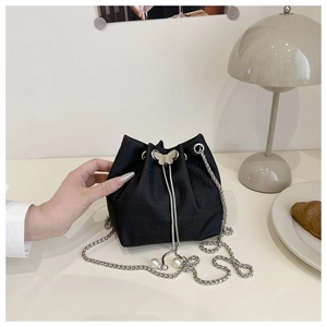 Détail du sac seau à motif crocodile avec fermoir papillon et chaîne à perles fines