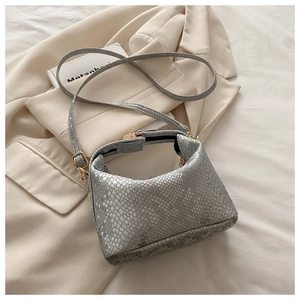 Detailed view of grey snake skin texture and gold twist lock on the fashion bucket bag