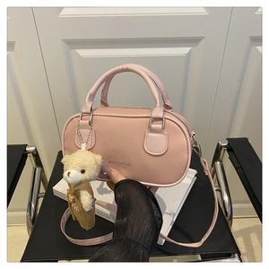 Detailed shot of pink pebble leather bowling bag with cute plush bear charm hanging