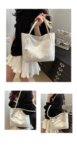 Detail of white lace tote bag featuring butterfly patterns and braided handles with tassel