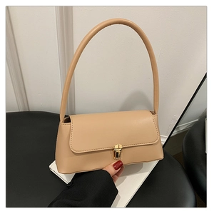Détail d'un sac baguette beige avec un fermoir en métal doré et une fine bandoulière chic