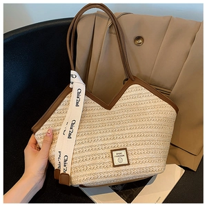 Detail showing the woven texture and V-shaped leather trim of this beige beach tote bag