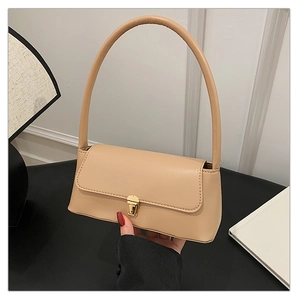 Détail d'un élégant sac sous le bras en cuir beige avec fermoir rotatif doré métallique