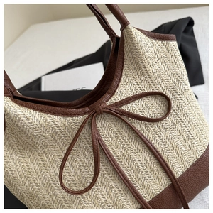 Detail of herringbone weave texture with brown lychee leather trim and bow on tote