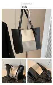 Detail view of the tricolor patchwork tote bag in grey, beige, and black matte leather