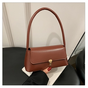 Détail du sac baguette marron rouge avec fermoir en métal doré et similicuir lisse