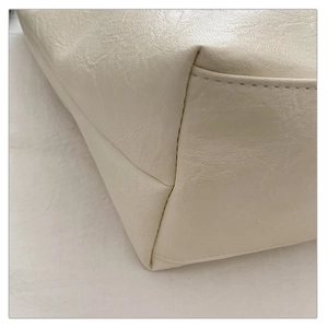 Dettaglio della borsa tote color crema con trama in pelle e cuciture precise sui bordi