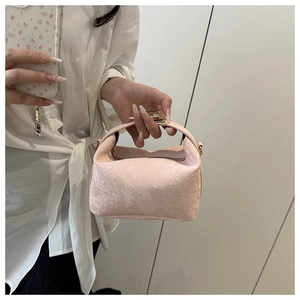 Detailed view of pink snake pattern leather handbag with gold metal hardware and clasp