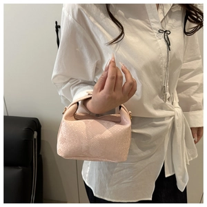 Close-up of pink snake skin pattern handbag with golden metal hardware and curved handle