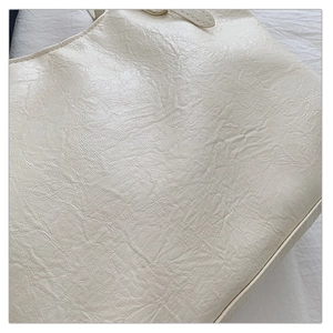 Dettaglio della borsa tote color crema con trama in ecopelle e cuciture di precisione