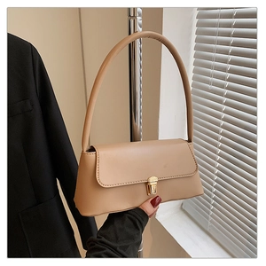 Détail du sac beige sous l'aisselle montrant le fermoir en métal et le cuir lisse PU