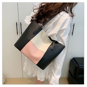 Detail of a large color-block tote bag with adjustable straps in pink, beige, and black