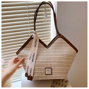 Macro detail of handwoven straw tote with premium brown leather trim and logo patch