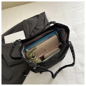 Detail of black tote bag showing large capacity with woven handles and 3D texture