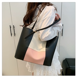 Detail of color-block tote bag featuring black, cream, and pink panels with fine texture