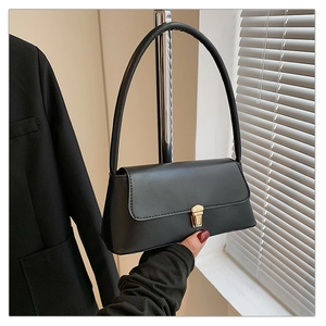 Détail d'un sac baguette en cuir noir avec un fermoir en métal doré élégant et chic