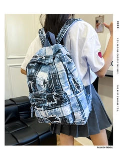 Rear view of model wearing a vintage patchwork denim backpack with graffiti print