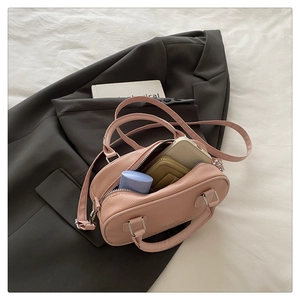Pink lychee grain leather mini bowling bag with dual handles and inner storage details