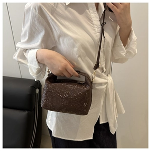 Macro shot of brown snakeskin texture small square crossbody bag with gold metal hardware