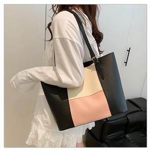 Detail of adjustable golden buckle on black shoulder strap of tricolor leather tote bag