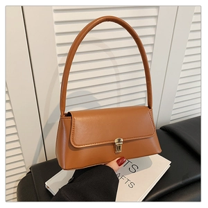 Détail d'un sac porté épaule en similicuir marron avec un fermoir doré sophistiqué