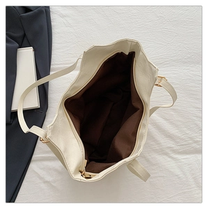 Dettaglio macro della borsa tote crema con fodera marrone e chiusura a zip dorata