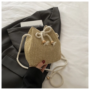 Detailansicht der Strohbeuteltasche mit Kordelzug und goldenen Perlenakzenten