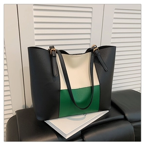Detail of color-block tote bag with lychee texture and adjustable metal buckle