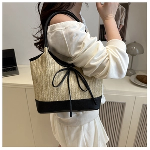 Detailansicht der beigen Stroh-Tote-Bag mit schwarzem Lederboden und Seitenschleife