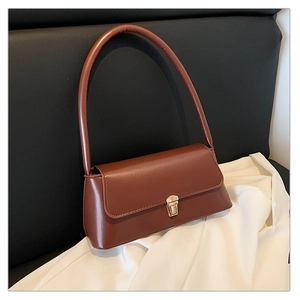 Gros plan d'un sac baguette en cuir marron vintage avec fermoir boucle dorée minimaliste