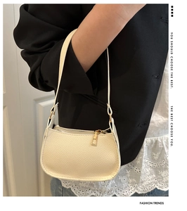 Detail der cremeweißen Halbmond-Schultertasche aus PU-Leder mit feiner Lychee-Narbung