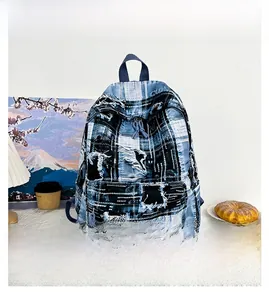 Detail of distressed blue and white checkered denim backpack with frayed edges and texture