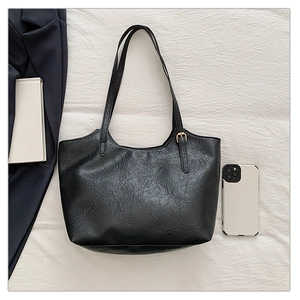 Dettaglio della borsa tote vintage in pelle PU nera con texture stropicciata e fibbia