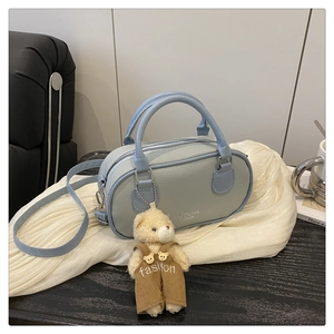 Detail of light blue lychee pattern bowling bag with a cute brown plush bear charm