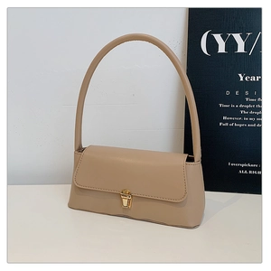Détail du fermoir métallique vintage doré sur le sac à bandoulière en similicuir beige