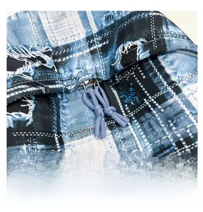 Detailed macro view of smooth metal zipper and blue woven pullers on plaid canvas bag