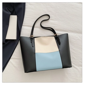 Detail of multi-color tote bag featuring premium leather texture and golden metal buckle