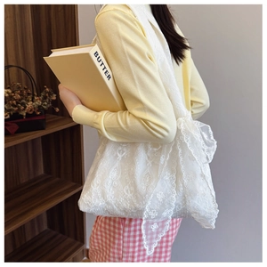 Close-up of white floral lace embroidery and wavy lace edges on a stylish tote bag